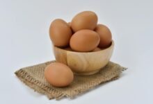 brown eggs on brown wooden bowl on beige knit textile