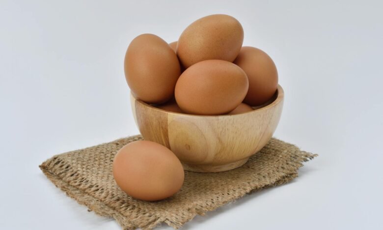 brown eggs on brown wooden bowl on beige knit textile