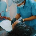 a woman getting her teeth checked by a dentist