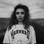 young girl on the beach in a harvard t shirt