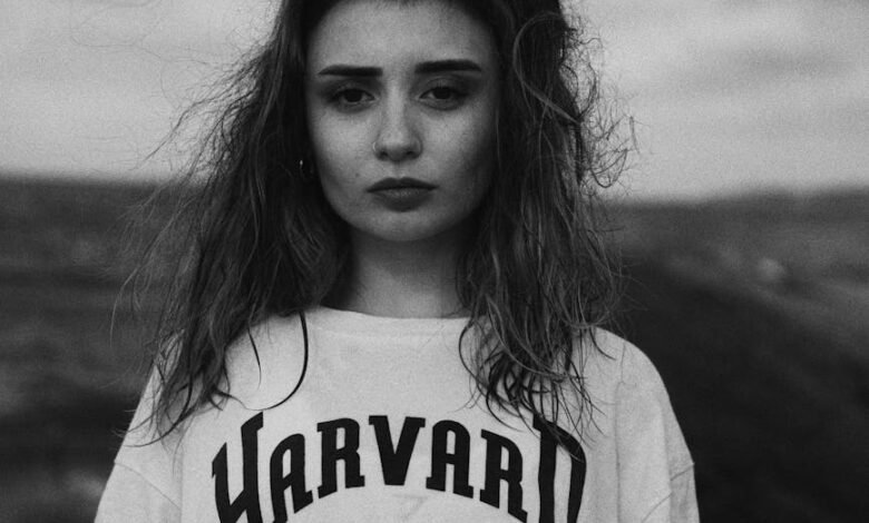 young girl on the beach in a harvard t shirt