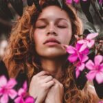 woman surrounded by pink petaled flowers