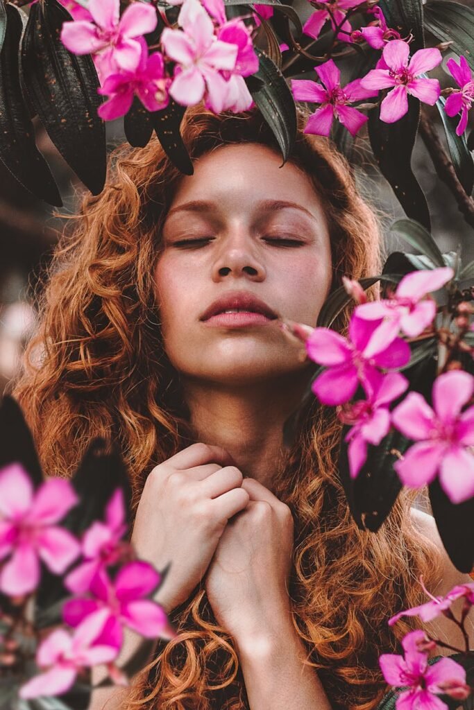 woman surrounded by pink petaled flowers