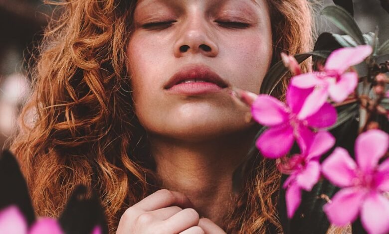 woman surrounded by pink petaled flowers