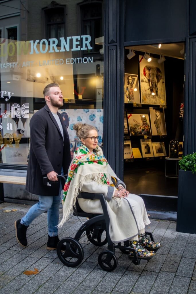 man pushing elderly lady on a wheelchair