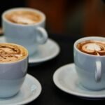 three cups of coffee with different designs on them