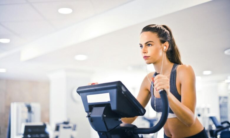 young female athlete training alone on treadmill in modern gym