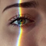 anonymous woman with rainbow light on face