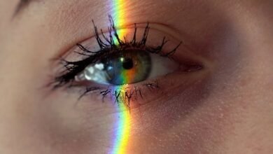 anonymous woman with rainbow light on face