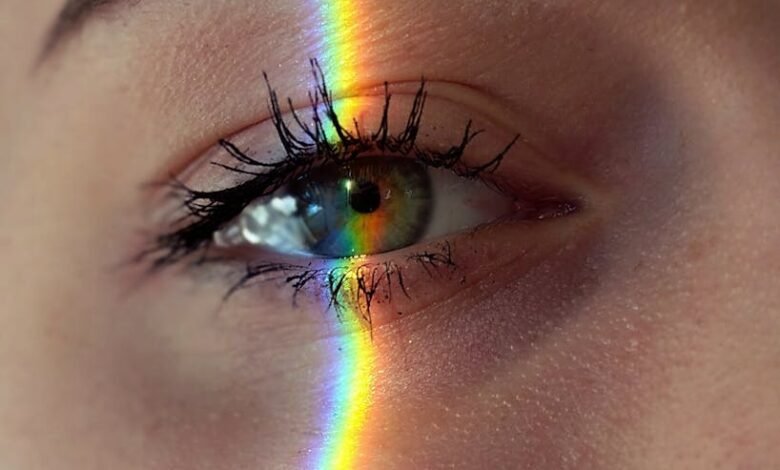 anonymous woman with rainbow light on face