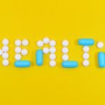 white and blue health pill and tablet letter cutout on yellow surface