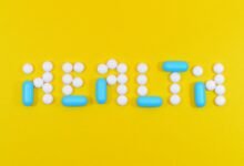 white and blue health pill and tablet letter cutout on yellow surface