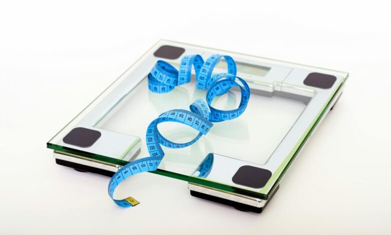 blue tape measuring on clear glass square weighing scale