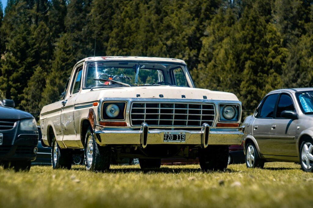 old ford pickup truck in a grassy parking lot