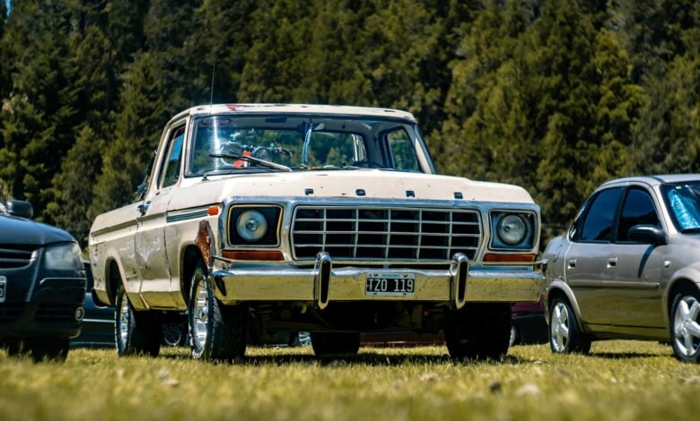 old ford pickup truck in a grassy parking lot