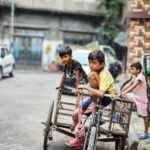 boys sitting on bike with trailer