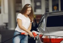 focused young woman refueling car