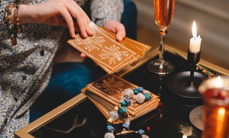 close up of woman holding a deck of tarot cards and sitting at a table with champagne glasses