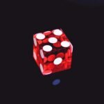 red translucent die on top of black surface