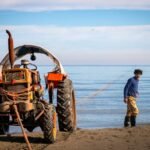 tractor by fisherman on sandy beach