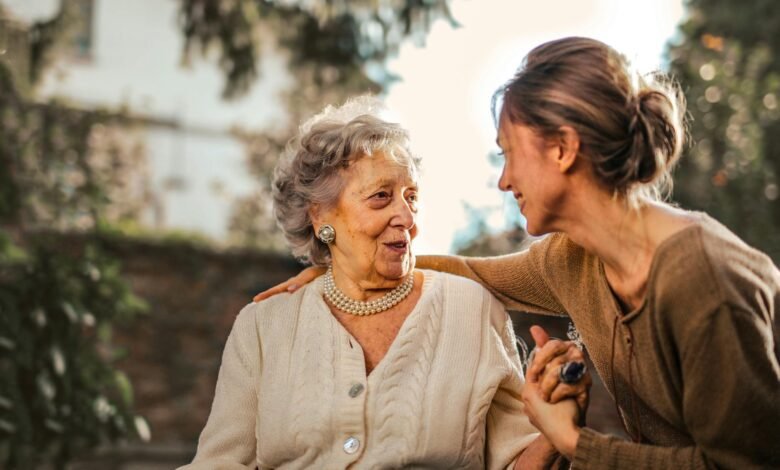 joyful adult daughter greeting happy surprised senior mother in garden