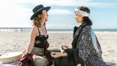 two women sitting on the beach