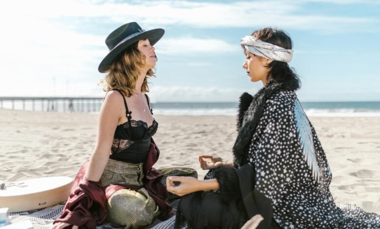 two women sitting on the beach