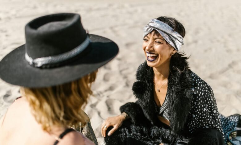 two women sitting on the beach