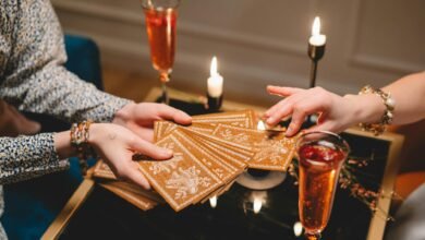 close up of woman picking a tarot card from a deck held by another woman