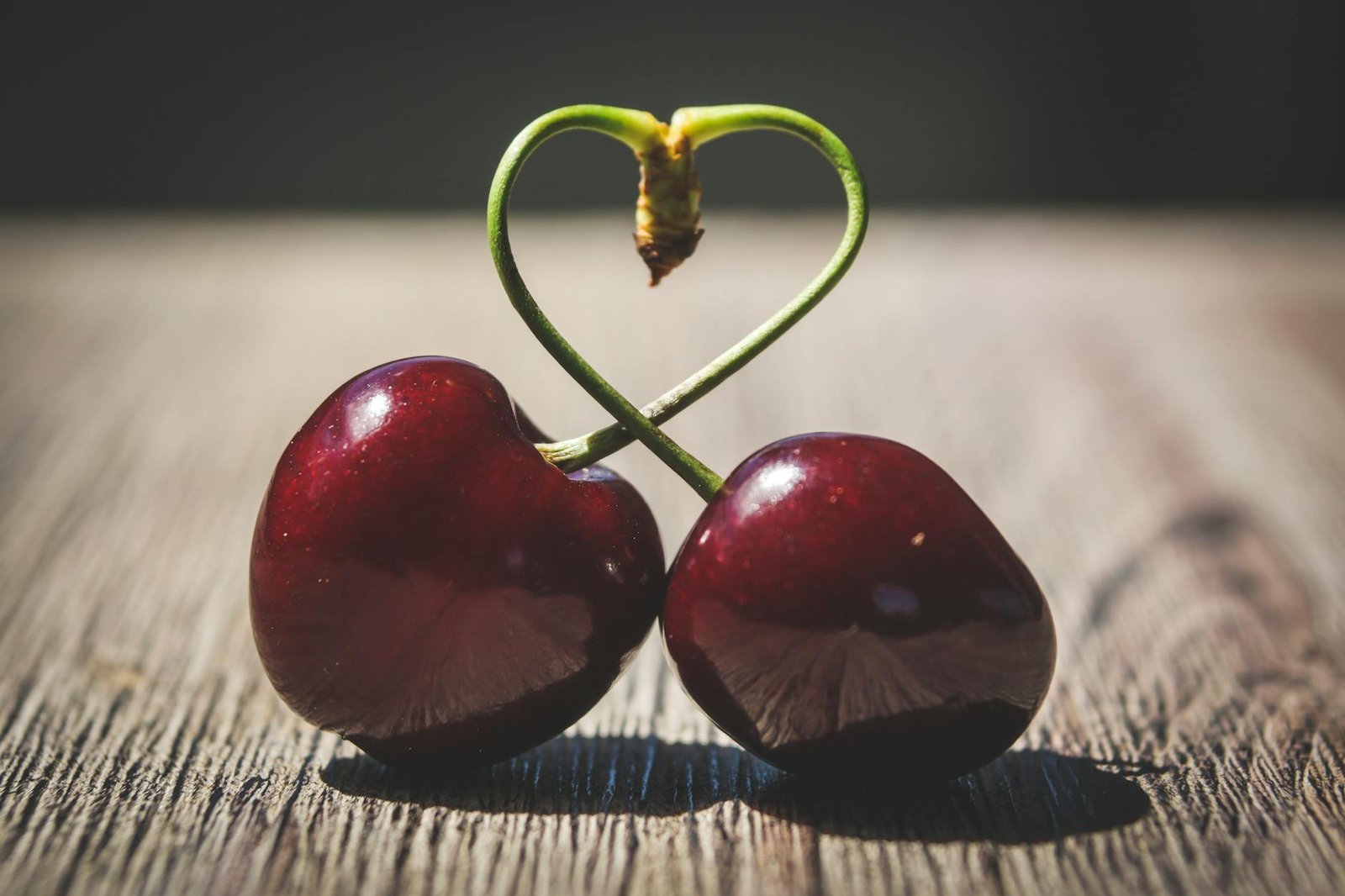 two red cherries on brown surface