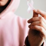 woman holding pink ribbon