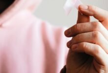 woman holding pink ribbon